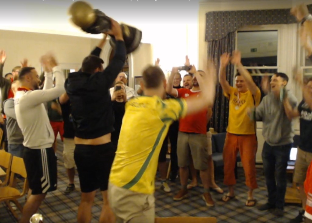 Blazej lifts the Amiga SWOS World Cup trophy high above his head while the crowd around him cheers on Saturday night in Cambridge.